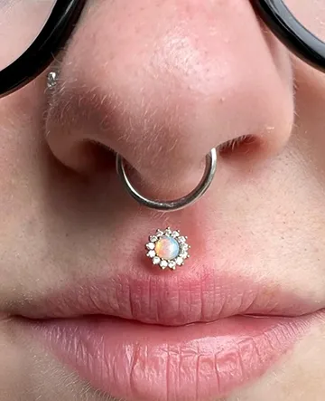 Close-up of a septum piercing with a small decorative ring