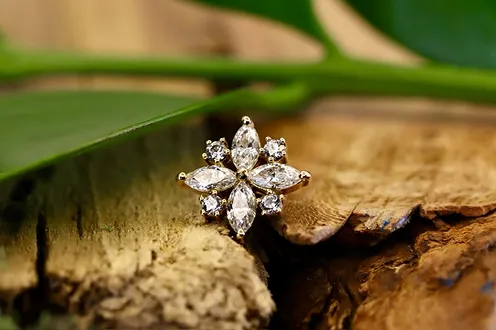 A ring featuring gemstones resting on a flower.